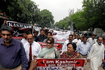 Demonstrators hold signs and chant slogans as they march in solidarity with the people of Kashmir, during a rally in Karachi