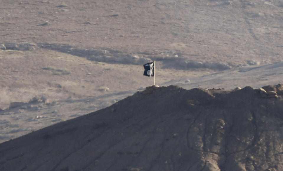 A black flag belonging to the Islamic State is seen near the Syrian town of Kobani, as pictured from the Turkish-Syrian border near the southeastern town of Suruc in Sanliurfa province, October 6, 2014. Islamic State militants raised their flag on a building on the eastern outskirts of the Syrian border town of Kobani on Monday after an assault of almost three weeks, but the town's Kurdish defenders said they had not reached the city centre. A black flag belonging to Islamic State was visible from across the Turkish border atop a four-storey building close to the scene of some of the most intense clashes in recent days. REUTERS/Umit Bektas (TURKEY - Tags: CONFLICT POLITICS)