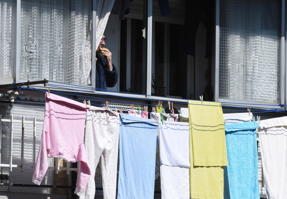 Un hombre toma algo de comida mientras observa el exterior desde la ventana de su casa de Madrid. (Foto: Jorge Sanz / SOPA Images / LightRocket / Getty Images).