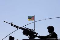 Rwandan police officer holds a machine gun on top of APC at an airport in Mocimboa da Praia