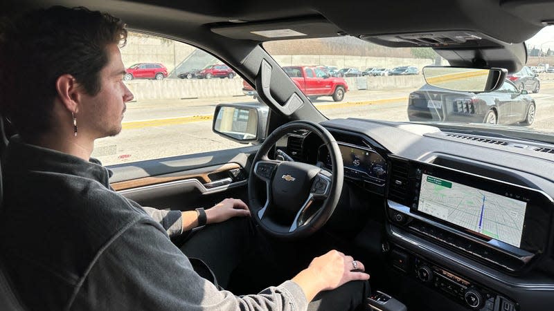 A photo of me resting my hands on my knees while the truck drives itself on the freeway