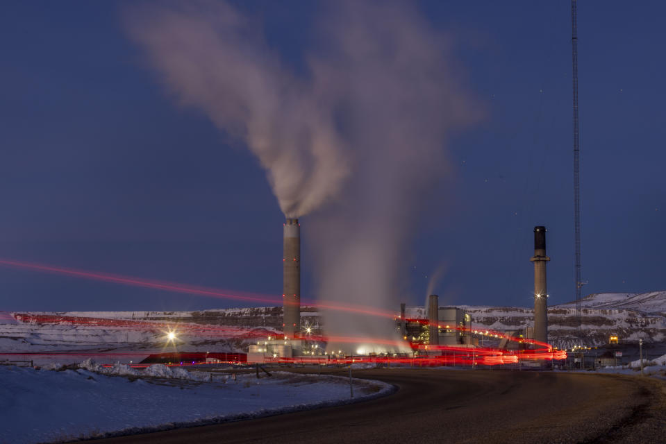 In this photo taken with a slow shutter speed, taillights trace the path of a motor vehicle at the Naughton Power Plant, Thursday, Jan. 13, 2022 in Kemmerer, Wyo. While the power plant will be closed in 2025, Bill Gates' company TerraPower announced it had chosen Kemmerer for a nontraditional, sodium-cooled nuclear reactor that will bring on workers from a local coal-fired power plant scheduled to close soon. (AP Photo/Natalie Behring)