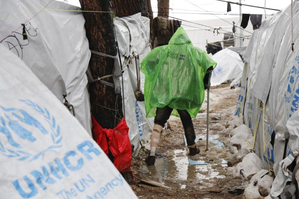 A refugee jumps over a pool of mud at Moria refugee camp on the eastern Greek island of Lesbos, Tuesday, Jan. 10, 2017. Officials said they planned to move some 250 people Tuesday, following strong criticism from aid agencies and medical associations that refugees had been left unprotected during the last heavy snowfall. (Petros Tsakmakis/InTime News via AP)