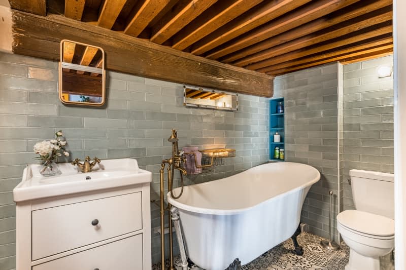 Bathroom with tile wall and clawfoot tub.
