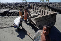 Children collect wood from remnants of some 20 boats that ferried Rohingya refugees fleeing violence in Myanmar, which were destroyed by Bangladeshi authorities the night before, at Shah Porir Dwip near Cox's Bazar, Bangladesh October 4, 2017. REUTERS/Damir Sagolj