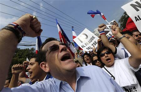 A supporter of Norman Quijano, presidential candidate of the conservative Nationalist Republican Alliance party (ARENA), shouts as others carry placards during a protest regarding alleged electoral fraud near the Supreme Electoral Court in San Salvador March 11, 2014. REUTERS/Henry Romero