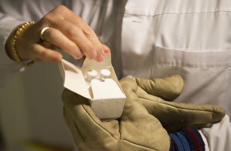 A medical staff holds a package of an experimental candidate vaccine rVSV-ZEBOV against Ebola virus disease at the University hospital in Geneva October 22, 2014. REUTERS/Mathilde Missioneiro/WHO/Handout via Reuters