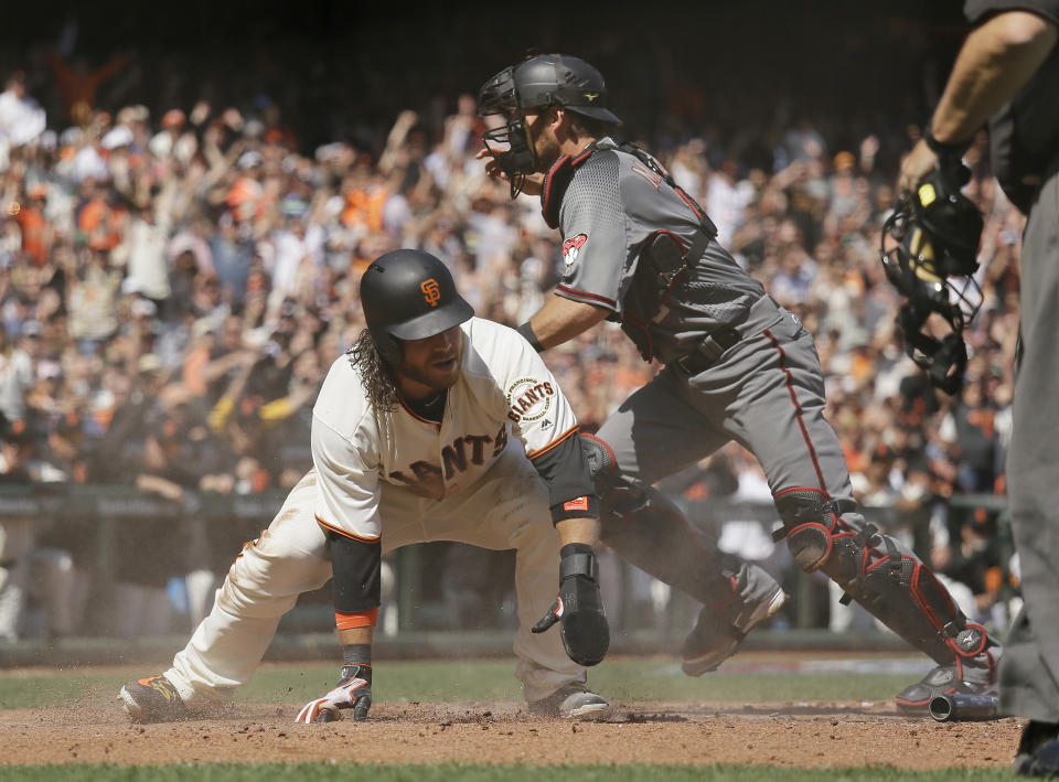 San Francisco Giants' Brandon Crawford, left, scores as Arizona Diamondbacks catcher Jeff Mathis, right, chases after the ball in the fourth inning of a baseball game, Monday, April 10, 2017, in San Francisco. (AP Photo/Eric Risberg)