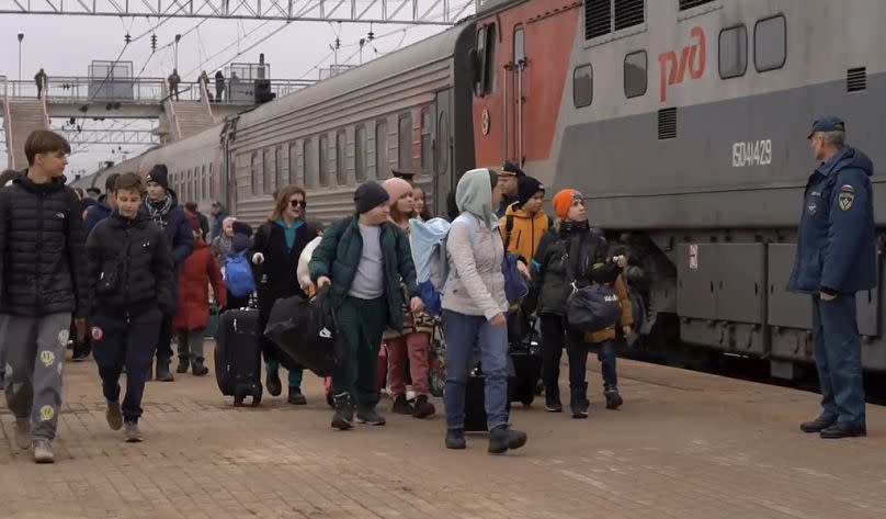 Niños deportados de asentamientos en la frontera de Ucrania suben a un tren para realojarse en Penza, en la región rusa de Bélgorod, en marzo de 2024.