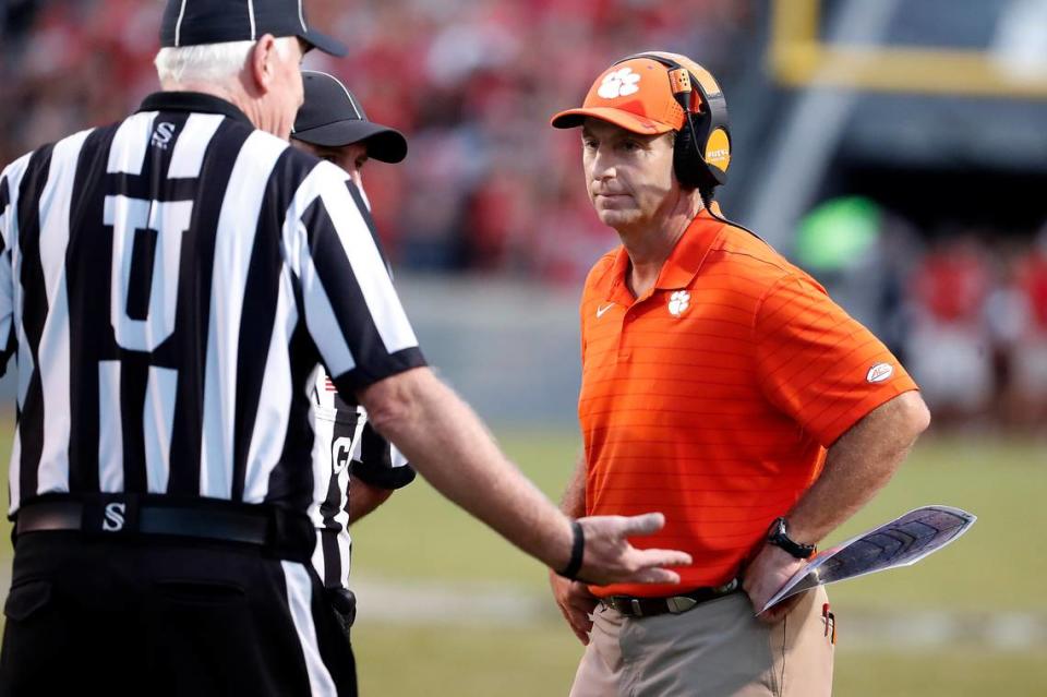 Clemson head coach Dabo Swinney, right, speaks with officials during the second half of an NCAA college football game against North Carolina State in Raleigh, N.C., Saturday, Sept. 25, 2021. (AP Photo/Karl B DeBlaker)