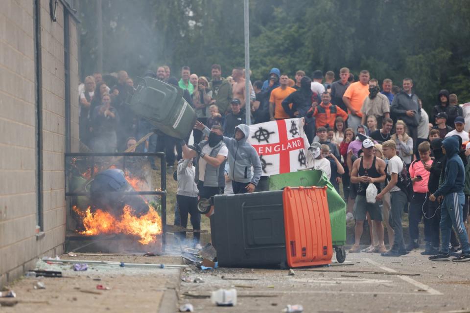 A large mob gathers outside the Holiday Inn Express in Manvers, a suburb of Rotherham, on Sunday before throwing debris at police (Danny Lawson/PA Wire)