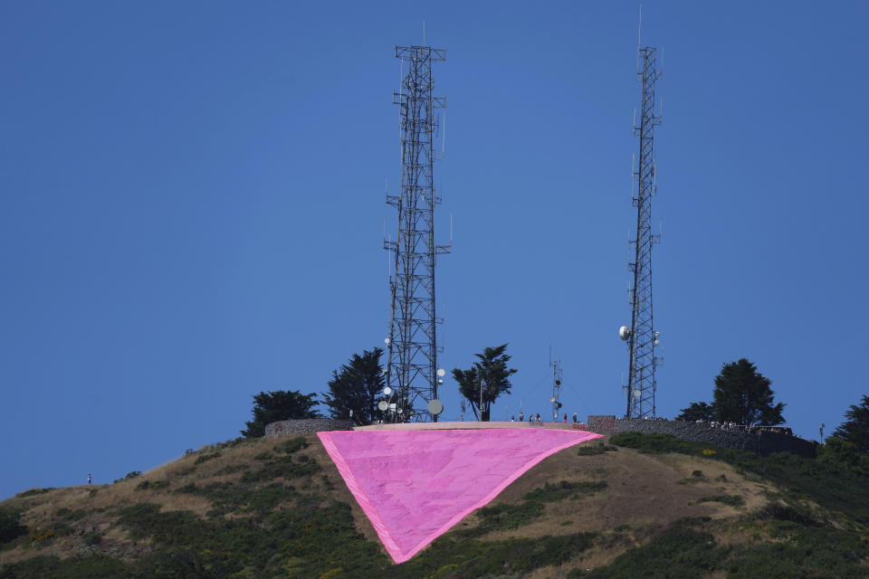 A pink triangle is seen on top of Twin Peaks in San Francisco, Tuesday, June 20, 2023. Hundreds of volunteers installed the giant pink triangle made out of cloth and canvas and with pink lights around its edges last week as part of the city's Pride celebrations. It's an annual tradition that started in 1995 but this year's triangle is nearly an acre in size and can be seen up to 20 miles (32 kms.) away. (AP Photo/Jeff Chiu)