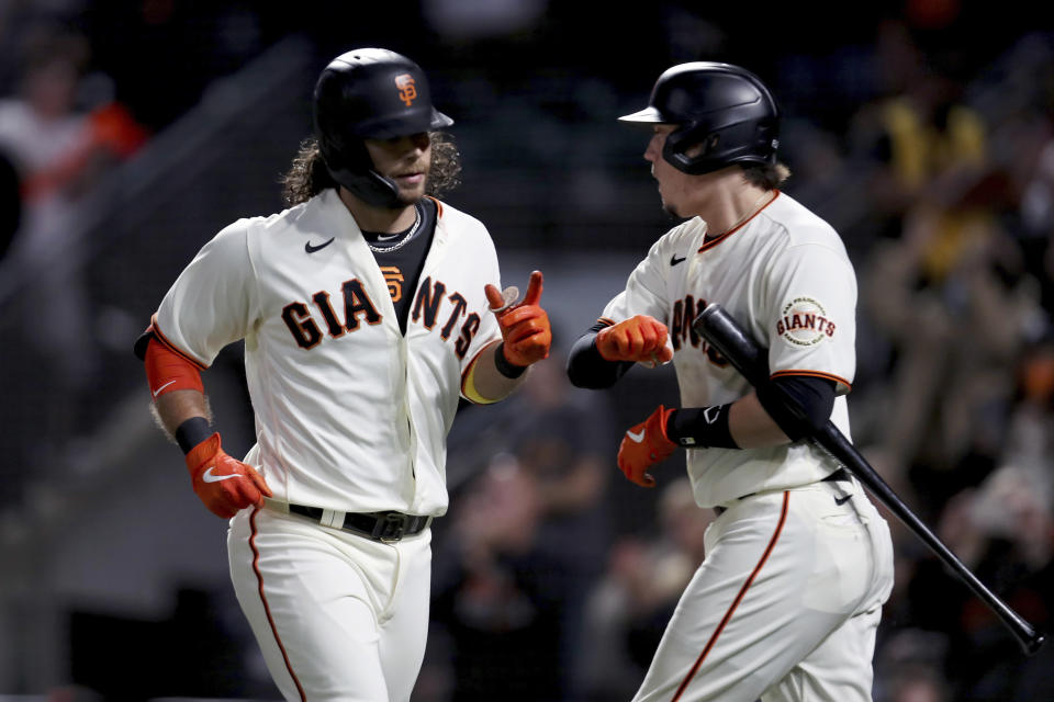 San Francisco Giants' Brandon Crawford, left, is congratulated by teammate Wilmer Flores after hitting a home run against the Arizona Diamondbacks during the fourth inning of a baseball game in San Francisco, Thursday, Sept. 30, 2021. (AP Photo/Jed Jacobsohn)