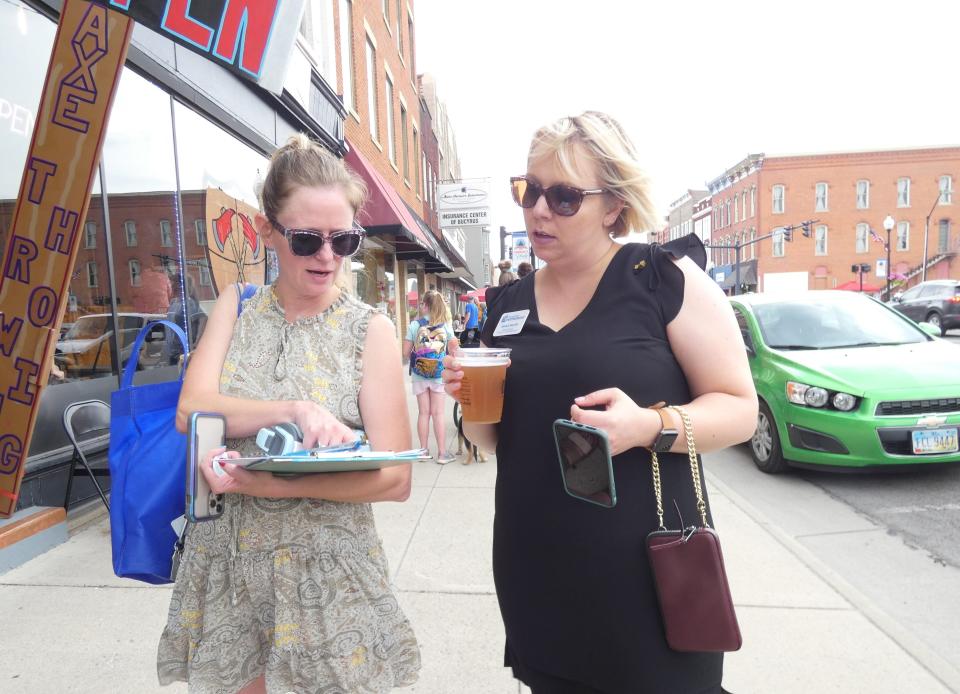 On her last official day as executive director of the Bucyrus Area Chamber of Commerce, Jessie Furner, left, discusses details of the city's DORA plan with Sarah Herrle of the Crawford Partnership during First Friday.