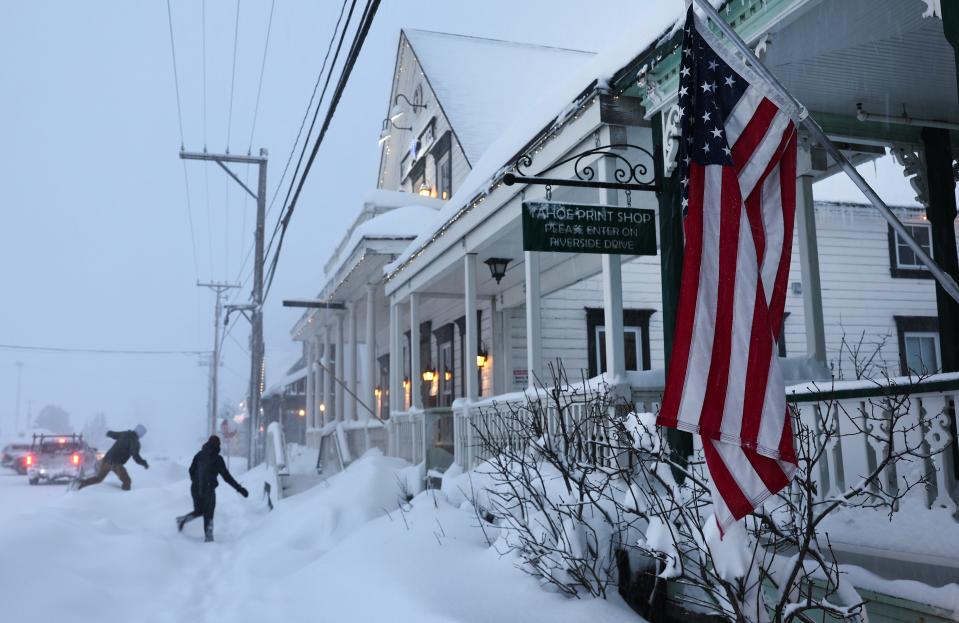 People walk during a powerful multiple day winter storm in the Sierra Nevada mountains on Saturday in Truckee, California.