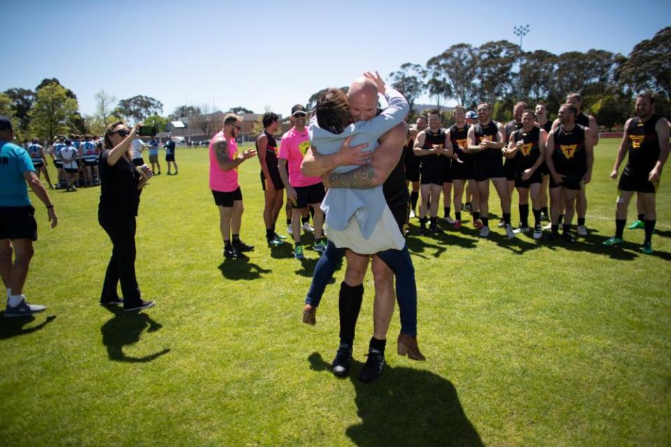 Tasmanian senator Jacqui Lambie gets a bear hug from one of the Tasmanian police AFL players at the 31st National Police Football Championships in Canberra