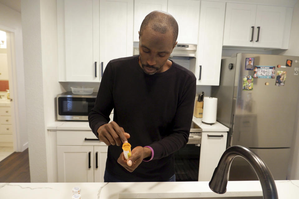 Anthony Jones takes his daily lupus medication and supplements at his Seattle apartment on June 20, 2023. Diagnosed with the disease when he was 19, Jones sometimes has difficulty making it to work when his lupus flares up. Washington lawmakers had cases like his in mind when they passed a new long-term care tax that takes effect July 1, making Washington the first state in the nation to deduct money from workers' paychecks to finance long-term care benefits. (AP Photo/Ed Komenda)