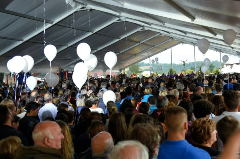 People attend a funeral service for victims of the earthquake, under a tent complex in Amatrice, on August 30, 2016