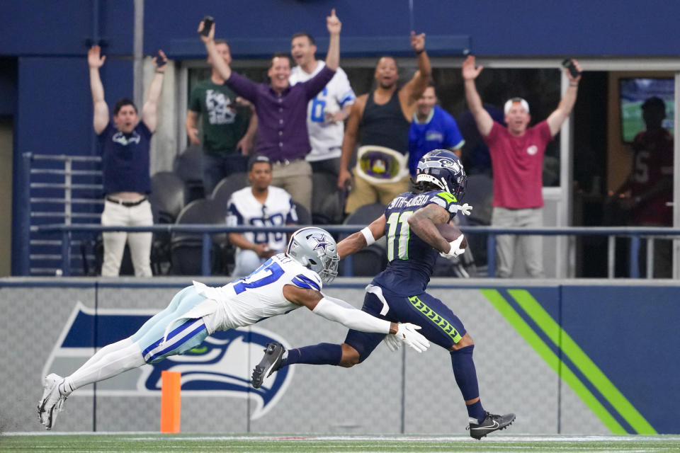 Seattle Seahawks wide receiver Jaxon Smith-Njigba catches a pass in front of Dallas Cowboys cornerback Eric Scott Jr. during the first half of a preseason NFL football game Saturday, Aug. 19, 2023, in Seattle. (AP Photo/Lindsey Wasson)