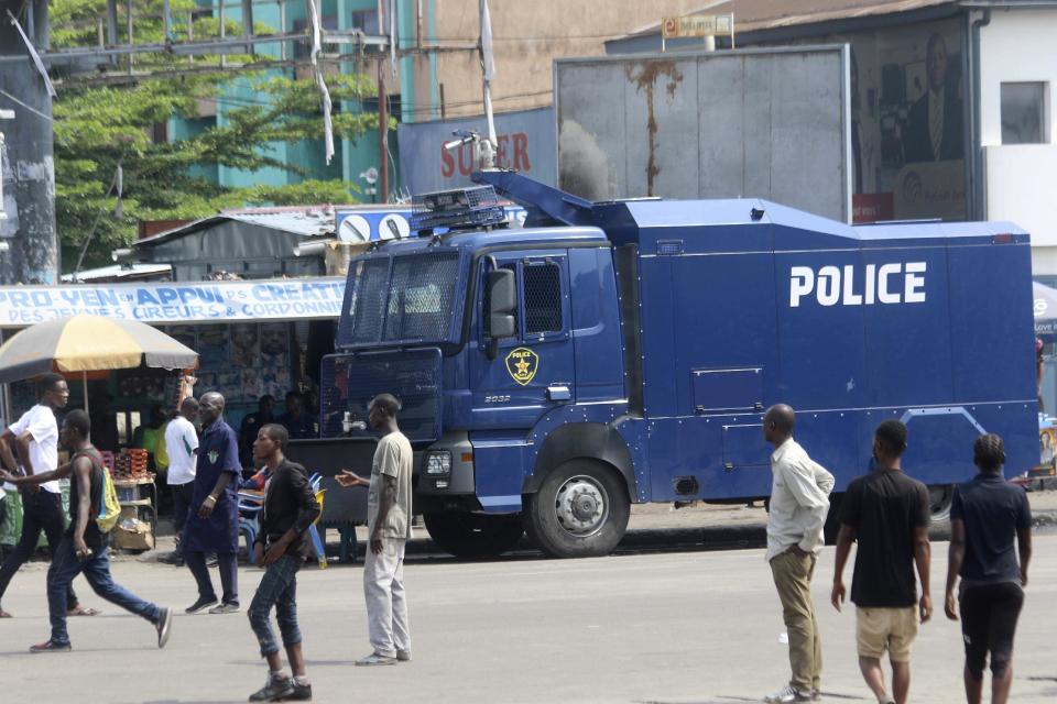 People walk past a police truck in Kinshasa, Congo, Monday, Dec. 19, 2016. Military and police units are deployed across the capital of Congo amid fears of unrest on the last official day of President Joseph Kabila's mandate. Kabila intends to stay on after the midnight deadline, as a court has ruled he can stay in power until new elections are held. (AP Photo/John Bompengo)
