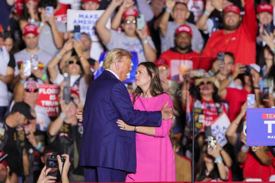 Former President Donald Trump and Arkansas Governor Sarah Sanders meet on stage during a rally at Ted Hendricks Stadium in Hialeah.