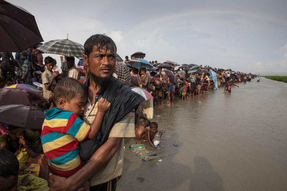 <p>Thousands of Rohingya refugees flee from Myanmar are kept under a tight security by Bangladeshi military after crossing the border in a rice paddy field near Palang Khali, Cox’s Bazar, Bangladesh, on October 16, 2017. A rainbow appeared after a brief rainstorm. Well over a half a million Rohingya refugees have fled into Bangladesh since late August during the outbreak of violence in Rakhine state causing a humanitarian crisis in the region with continued challenges for aid agencies. (Photograph by Paula Bronstein/Getty Images) </p>