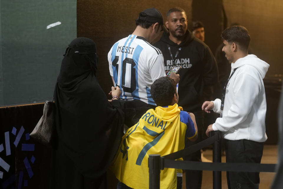 Saudi family members wear T-shirts of Lionel Messi and of Cristiano Ronaldo during the Riyadh Season Cup soccer match between Inter Miami and Al Nassr at Kingdom Arena Stadium in Riyadh, Saudi Arabia, Thursday, Feb. 1, 2024. (AP Photo/Amr Nabil)