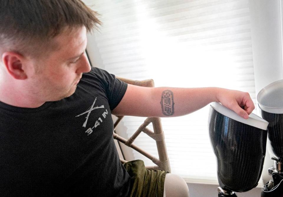 Adam Hartswick looks at the tattoo on his forearm of his four fellow Army soldiers that were killed on May 14, 2013 in Kandahar, Afghanistan, the same day he lost both of his legs. The soldiers were SFC Jeffrey C Baker, SPC Mitchell K Daehling, SPC William J Gilbert and SPC Cody J Towse.