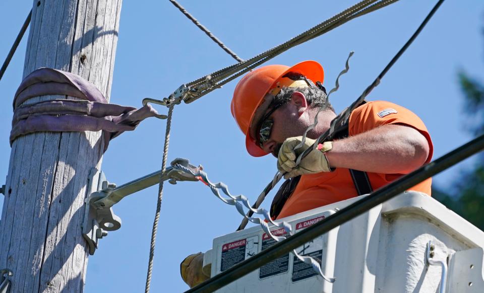 A worker installs fiber optic cable on a utility pole near Belfair, Wash.