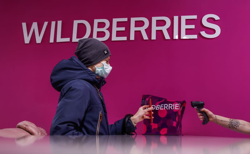 Employee of Wildberries online retailer scans a code on a screen of a smartphone at a pickup point in Moscow