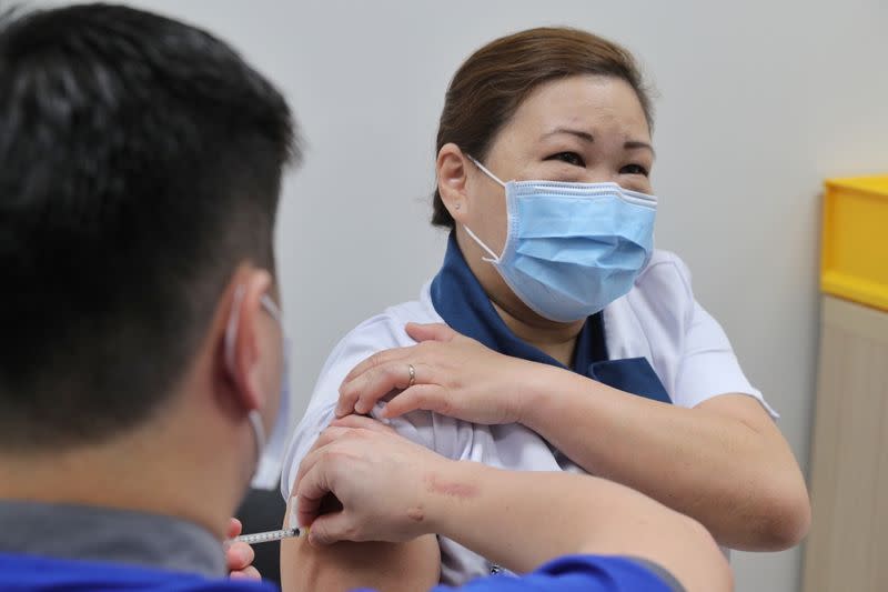 Healthcare worker Sarah Lim receives her coronavirus disease (COVID-19) vaccine at the National Centre for Infectious Diseases (NCID) in Singapore