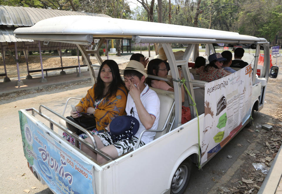 In this March 30, 2014 photo, Chinese tourists ride on a cart while touring Chiang Mai University in Chiang Mai province, northern Thailand. The bucolic, once laid-back campus of one of Thailand’s top universities is under a security clampdown. Not against a terrorist threat, but against Chinese tourists. Thousands have clambered aboard student buses at the university, made a mess in cafeterias and sneaked into classes to attend lectures. Someone even pitched a tent by a picturesque lake. The reason: “Lost in Thailand,” 2012 slapstick comedy partly shot on campus that is China’s highest-grossing homegrown movie ever. (AP Photo/Apichart Weerawong) (AP Photo/Apichart Weerawong)