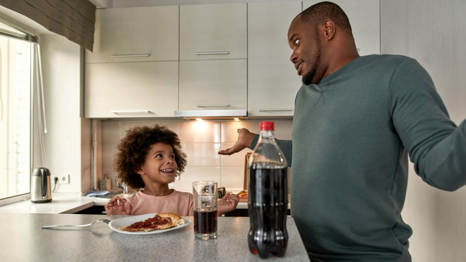 A father shrugging while talking to his child