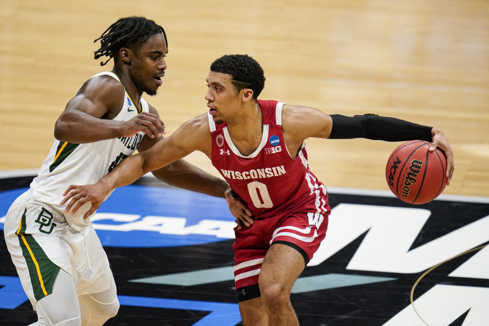 Wisconsin guard D'Mitrik Trice (0) drives on Baylor guard Davion Mitchell (45) in the first half of a second-round game in the NCAA men's college basketball tournament at Hinkle Fieldhouse in Indianapolis, Sunday, March 21, 2021. (AP Photo/Michael Conroy)