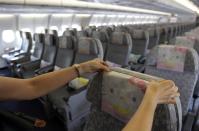 The Hello Kitty motif is pervasive. Here, a flight attendant arranges a Hello Kitty headrest cover inside an Eva Airlines aircraft.