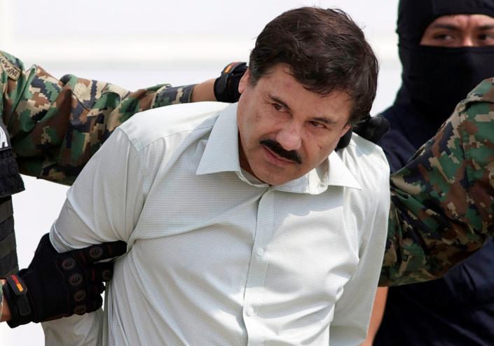 FILE - In this Feb. 22, 2014 file photo, Joaquin "El Chapo" Guzman, the head of Mexico's Sinaloa Cartel, is escorted to a helicopter in Mexico City following his capture in the beach resort town of Mazatlan, Mexico. The Mexican drug kingpin, who was convicted in a New York federal court in February 2019 on multiple conspiracy counts in an epic drug-trafficking case, was sentenced to life behind bars in a U.S. prison. (AP Photo/Eduardo Verdugo, File)