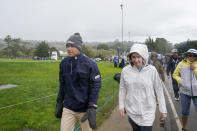 Peter Malnati, left, exits Pebble Beach Golf Links after the third round of the AT&T Pebble Beach Pro-Am golf tournament was suspended due to wind in Pebble Beach, Calif., Saturday, Feb. 4, 2023. (AP Photo/Godofredo A. Vásquez)