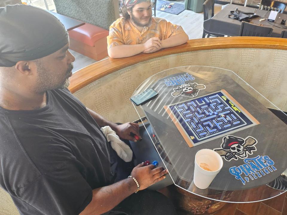 Cooks Kevin Williams and Alden Duplechin play Pac Man on arcades at Pirate's Pizzeria, May 29. The restaurant is currently doing takeout but opens to dine in on June 3.