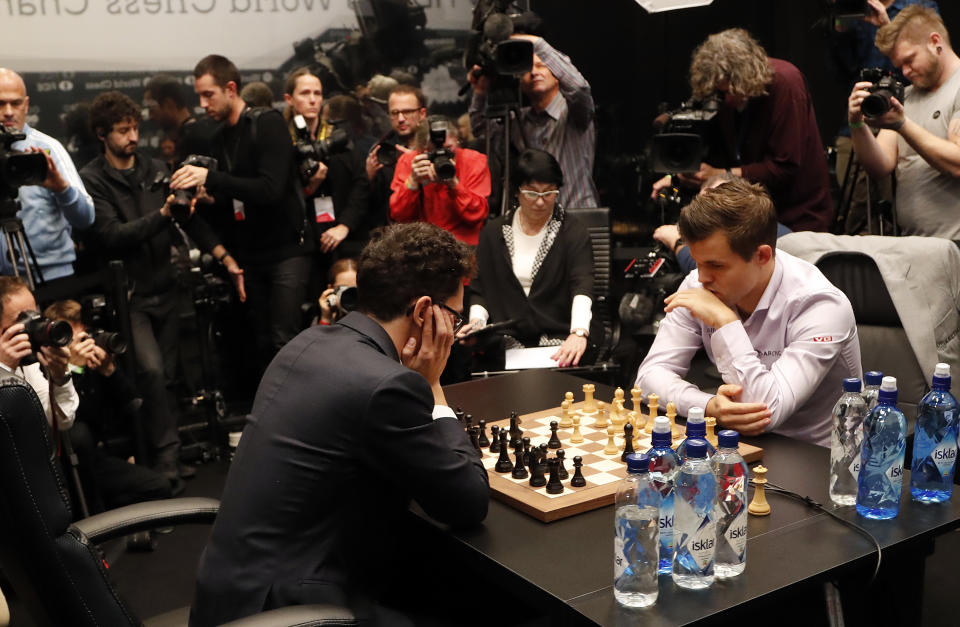 Campeón mundial de ajedrez Magnus Carlsen, derecha, y el italiano-estadounidense Fabiano Caruana. 28 de noviembre de 2018. (Foto AP / Frank Augstein)