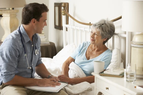 Doctor sitting on bed of a female patient