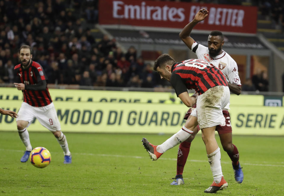 Patrick Cutrone, derecha, de Milan, realiza un disparo al arco en partdo de la Serie A frente a Torino en el estadio San Siro de Milán, Italia, el domingo 9 de diciembre de 2018. (AP Foto/Luca Bruno)