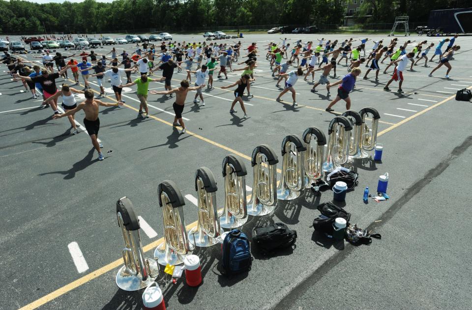 Members of the Carmel High School Marching Greyhounds stretch before the start of band practice in the parking lot outside the football stadium at the school Wednesday August 10, 2011. The 209 members of the band and color guard will perform their show "Going Viral" at football games and during band competitions, and will march in the Macy's Thanksgiving Day Parade in New York City this fall.