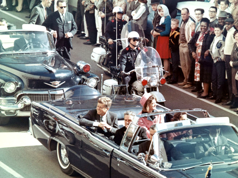 JFK and his wife Jackie ride in the motorcade shortly before his assassination (Getty)