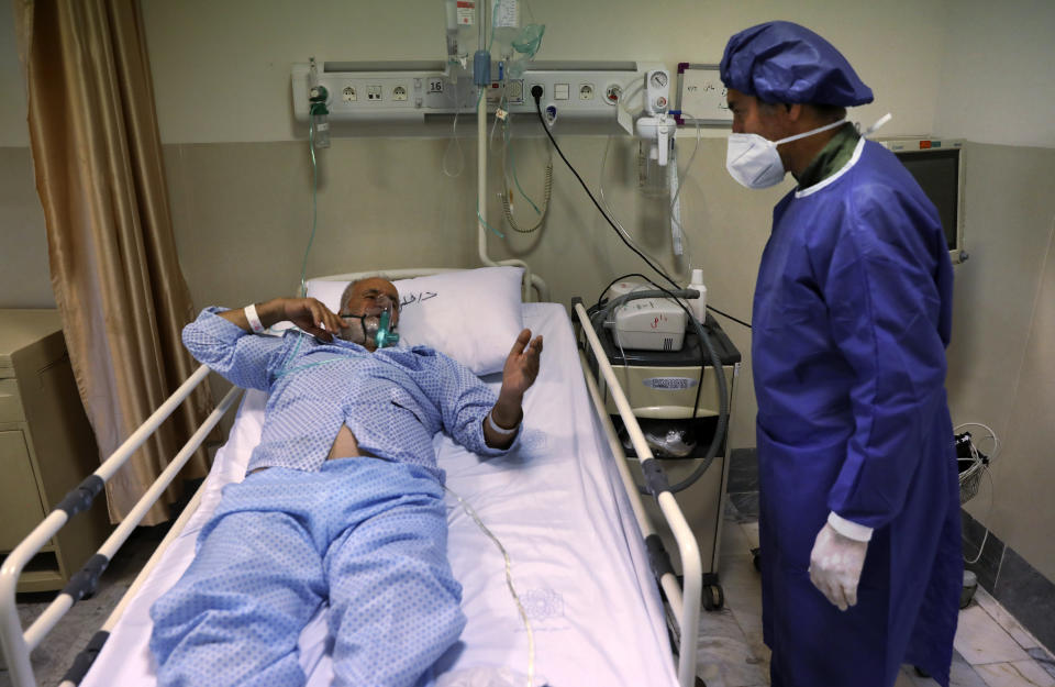 In this Tuesday, June 16, 2020, photo, a COVID-19 patient speaks with a medic at the Shohadaye Tajrish Hospital in Tehran, Iran. After months of fighting the coronavirus, Iran only just saw its highest single-day spike in reported cases after Eid al-Fitr, the holiday that celebrates the end of Ramadan. (AP Photo/Vahid Salemi)