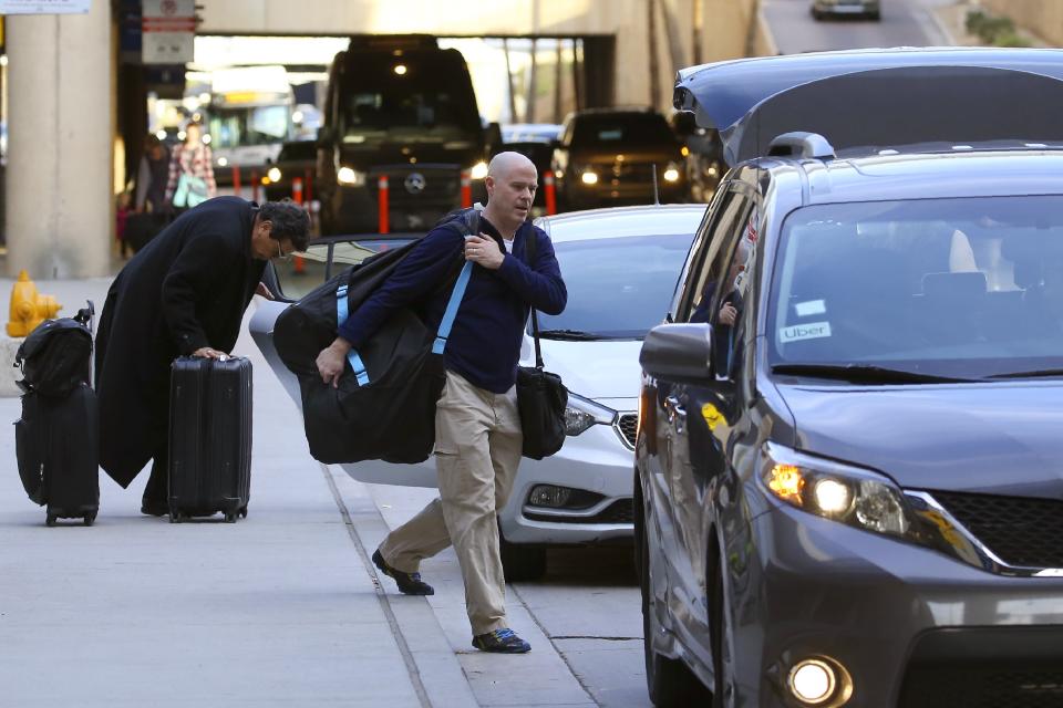 Passengers find their rides at the Ride Share point as they exit Phoenix Sky Harbor International Airport Wednesday, Dec. 18, 2019, in Phoenix. The Phoenix City Council is set to vote on raising fees charged to ride-hailing companies at the airport. If approved Wednesday afternoon, the proposal will increase the current fee from $2.66 per pickup. That would jump to $4 starting Jan. 1 and be applied to drop-offs as well. (AP Photo/Ross D. Franklin)