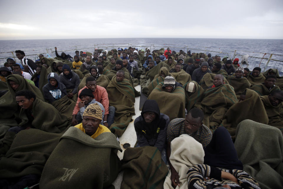 ARCHIVO - Migrantes sentados en la cubierta del barco de la Marina belga Godetia después de ser rescatados en el mar durante una misión de búsqueda y rescate en el Mediterráneo cerca de la costa libia, el 24 de junio de 2015. (AP Foto/Gregorio Borgia, Archivo)