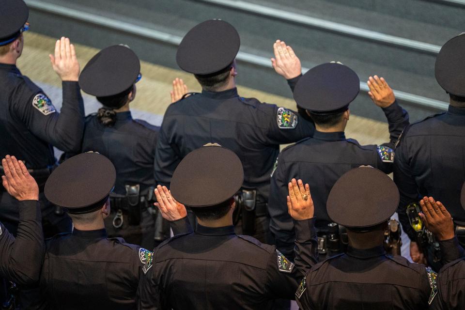 Cadets raise their hands as they take the oath of office during the Austin Police Department's commencement ceremony for the 149th cadet class at Bannockburn Church in South Austin on Jan. 5.