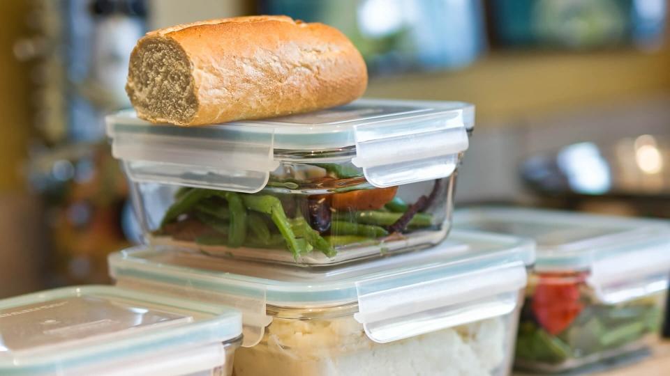 Containers of leftover food stacked on kitchen counrter.