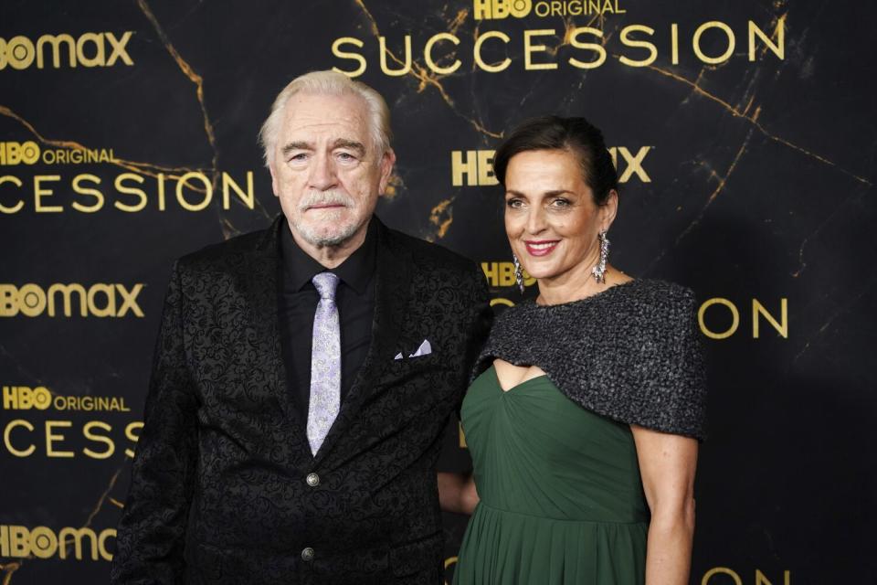 Brian Cox and Nicole Ansari-Cox pose together in formal attire.