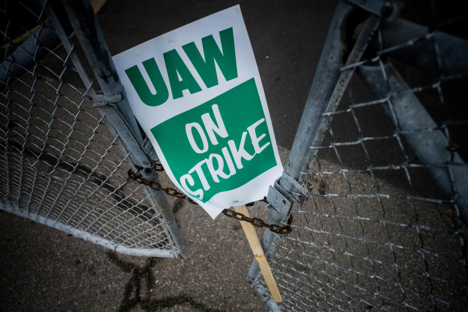 FILE - In this Sept. 16, 2019, file photo, a United Auto Workers strike sign rests between the chains of a locked gate entrance outside of Flint Engine Operations in Flint, Mich. General Motors CEO Mary Barra joined negotiators at the bargaining table Tuesday, Oct. 15, an indication that a deal may be near to end a monthlong strike by members of the United Auto Workers union that has paralyzed the company’s factories. (Jake May/The Flint Journal via AP, File)